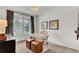 Cozy office with a light desk, brown leather stools, light colored walls, and a large window at 722 Ocmulgee Xing, Locust Grove, GA 30248