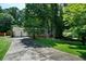 Exterior view of home with a long driveway and lush greenery at 5070 Maryland Nw Dr, Acworth, GA 30101
