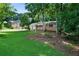Landscaped front yard featuring a brick home and mature trees at 5070 Maryland Nw Dr, Acworth, GA 30101