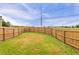 Fenced-in backyard with green grass, and utility pole in the background at 70 Trinity Lane, Covington, GA 30016