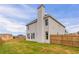 Wide backyard features a light colored exterior and wooden fence at 70 Trinity Lane, Covington, GA 30016