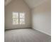 Bedroom with vaulted ceiling, neutral walls, and large window for natural light at 70 Trinity Lane, Covington, GA 30016