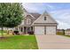Charming two-story home featuring a stone facade, attached two-car garage, and a beautifully landscaped front yard at 70 Trinity Lane, Covington, GA 30016