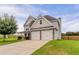 Charming home featuring stone accents, a two-car garage, well-maintained lawn, and a classic gable roof design at 70 Trinity Lane, Covington, GA 30016