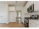 Bright kitchen featuring white cabinets, stainless steel appliances, and hardwood flooring with an open layout at 70 Trinity Lane, Covington, GA 30016