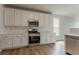 Modern kitchen features white cabinets, stainless steel appliances and wood flooring at 70 Trinity Lane, Covington, GA 30016