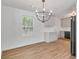 Bright dining area with new floors, a modern chandelier, and access to the updated kitchen with white cabinets at 1834 Stroud Road, Mcdonough, GA 30252