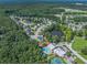 Community aerial view showcasing lush trees, a pool, and tennis courts near homes at 301 Retreat Way, Carrollton, GA 30116