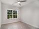 Bright bedroom with large windows offering wooded views and a modern ceiling fan at 301 Retreat Way, Carrollton, GA 30116