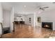 Open concept living space with hardwood floors, fireplace, ceiling fan, and access to the kitchen at 301 Retreat Way, Carrollton, GA 30116