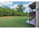 Large, well-manicured backyard featuring a covered deck with stairs leading to the lower level patio at 6415 Yellow Birch St, Cumming, GA 30040