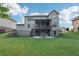 Scenic view of the large backyard, complete with a covered deck, stairs, and a lower level patio at 6415 Yellow Birch St, Cumming, GA 30040