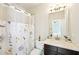 Bathroom boasts modern light fixture, a beautiful floral shower curtain and a tiled shower at 6415 Yellow Birch St, Cumming, GA 30040