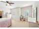 Bright bedroom featuring large windows, ceiling fan, and neutral decor at 6415 Yellow Birch St, Cumming, GA 30040