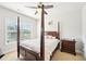 This bedroom is naturally lit with a four-poster bed and a large window overlooking the outdoors at 6415 Yellow Birch St, Cumming, GA 30040
