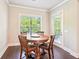 Cozy dining area featuring a round wooden table, hardwood floors, and natural light at 6415 Yellow Birch St, Cumming, GA 30040
