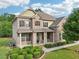 Stunning two-story home featuring a brick facade, covered porch, and manicured lawn and shrubbery at 6415 Yellow Birch St, Cumming, GA 30040