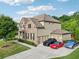 Exterior view of a two-story home featuring a brick and siding facade, a three-car garage, and a well-manicured lawn at 6415 Yellow Birch St, Cumming, GA 30040
