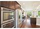 Modern kitchen with stainless steel appliances, double ovens, and adjacent breakfast area at 6415 Yellow Birch St, Cumming, GA 30040
