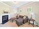 Cozy living room features a fireplace, comfortable seating, and natural light from the windows at 6415 Yellow Birch St, Cumming, GA 30040