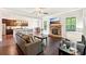 Cozy living room with a stone fireplace, ceiling fan, and views of the kitchen at 6415 Yellow Birch St, Cumming, GA 30040