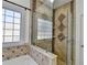 Updated bathroom features a glass shower door, tile walls, tub, and built-in shelves at 337 Inverness Ave, Mcdonough, GA 30253