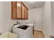 This laundry room includes storage cabinets, sink, tiled floors, washer, and dryer at 337 Inverness Ave, Mcdonough, GA 30253