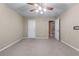 A carpeted bedroom with a ceiling fan and access to another area of the home at 971 Reap Ln, Lawrenceville, GA 30043
