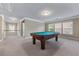 A carpeted game room with a pool table and natural light from multiple windows at 971 Reap Ln, Lawrenceville, GA 30043