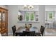 Dining room with a dark wood table and an open view into the kitchen, which has a french door at 11352 Musette Cir, Alpharetta, GA 30009
