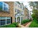 Exterior view of townhome with well-maintained landscaping and a sidewalk at 11352 Musette Cir, Alpharetta, GA 30009