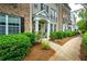 Exterior view of townhome with well-maintained landscaping and a sidewalk at 11352 Musette Cir, Alpharetta, GA 30009