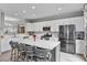 Bright kitchen featuring white cabinets, stainless appliances, and an island with barstool seating at 11352 Musette Cir, Alpharetta, GA 30009