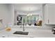 Kitchen and dining area featuring a stainless steel sink with quartz countertop and a view into the adjacent room at 11352 Musette Cir, Alpharetta, GA 30009