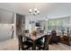 Living room with dining area featuring stairs, carpet flooring, and a large window at 11352 Musette Cir, Alpharetta, GA 30009