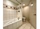 Tiled bathroom featuring a jacuzzi tub with tile surround, a toilet, and a shower with a shower head at 199 14Th Street Ne St # 704, Atlanta, GA 30309
