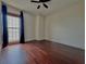 Cozy bedroom with hardwood floors, ceiling fan, and a window with black curtains at 199 14Th Street Ne St # 704, Atlanta, GA 30309
