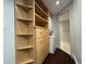 Bright laundry area with wood shelving and drawers, offering ample storage space next to the stacked washer and dryer at 199 14Th Street Ne St # 704, Atlanta, GA 30309