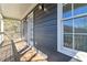 Charming back porch with wood flooring, white railings, and natural siding with large windows at 2395 Saint James Nw Dr, Atlanta, GA 30318