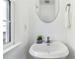 Modern bathroom with a white pedestal sink, oval mirror, towel rack, and a window for natural light at 2395 Saint James Nw Dr, Atlanta, GA 30318