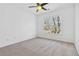 This bedroom has neutral carpet, white walls and trim, a ceiling fan, and a window overlooking a treed landscape at 2395 Saint James Nw Dr, Atlanta, GA 30318