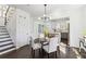 Dining area with dark floors and white chairs located adjacent to the kitchen at 2395 Saint James Nw Dr, Atlanta, GA 30318