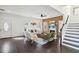 A spacious living room featuring stylish decor, dark wood floors, a fireplace, and stairs at 2395 Saint James Nw Dr, Atlanta, GA 30318