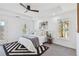 Serene main bedroom boasts a tray ceiling, ceiling fan, decorative rug, and natural light from multiple windows at 2395 Saint James Nw Dr, Atlanta, GA 30318