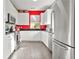 Bright kitchen with stainless steel appliances, white cabinets, granite countertops, and red accent wall at 10 Perimeter Summit Ne Br # 2312, Atlanta, GA 30319