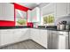 Kitchen with white cabinets, stainless steel appliances, granite countertops, and red accent wall at 10 Perimeter Summit Ne Br # 2312, Atlanta, GA 30319