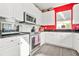 Kitchen with stainless steel appliances, white cabinetry, granite countertops, and red accent wall at 10 Perimeter Summit Ne Br # 2312, Atlanta, GA 30319