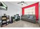 Living room space with gray sofa, dark wood desk and chair, and a red accent wall at 10 Perimeter Summit Ne Br # 2312, Atlanta, GA 30319