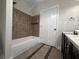 Bathroom featuring a tub with tiled walls and updated flooring, a neutral color palette, and a modern vanity at 1647 Walker Ave, Atlanta, GA 30337
