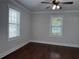 Bedroom featuring hardwood floors, a ceiling fan, two windows with blinds, and a neutral color scheme at 1647 Walker Ave, Atlanta, GA 30337